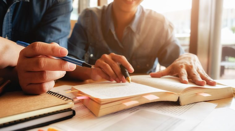 Education concept. Student studying and brainstorming campus con Education concept. Student studying and brainstorming campus concept. Close up of students discussing their subject on books or textbooks. Selective focus.